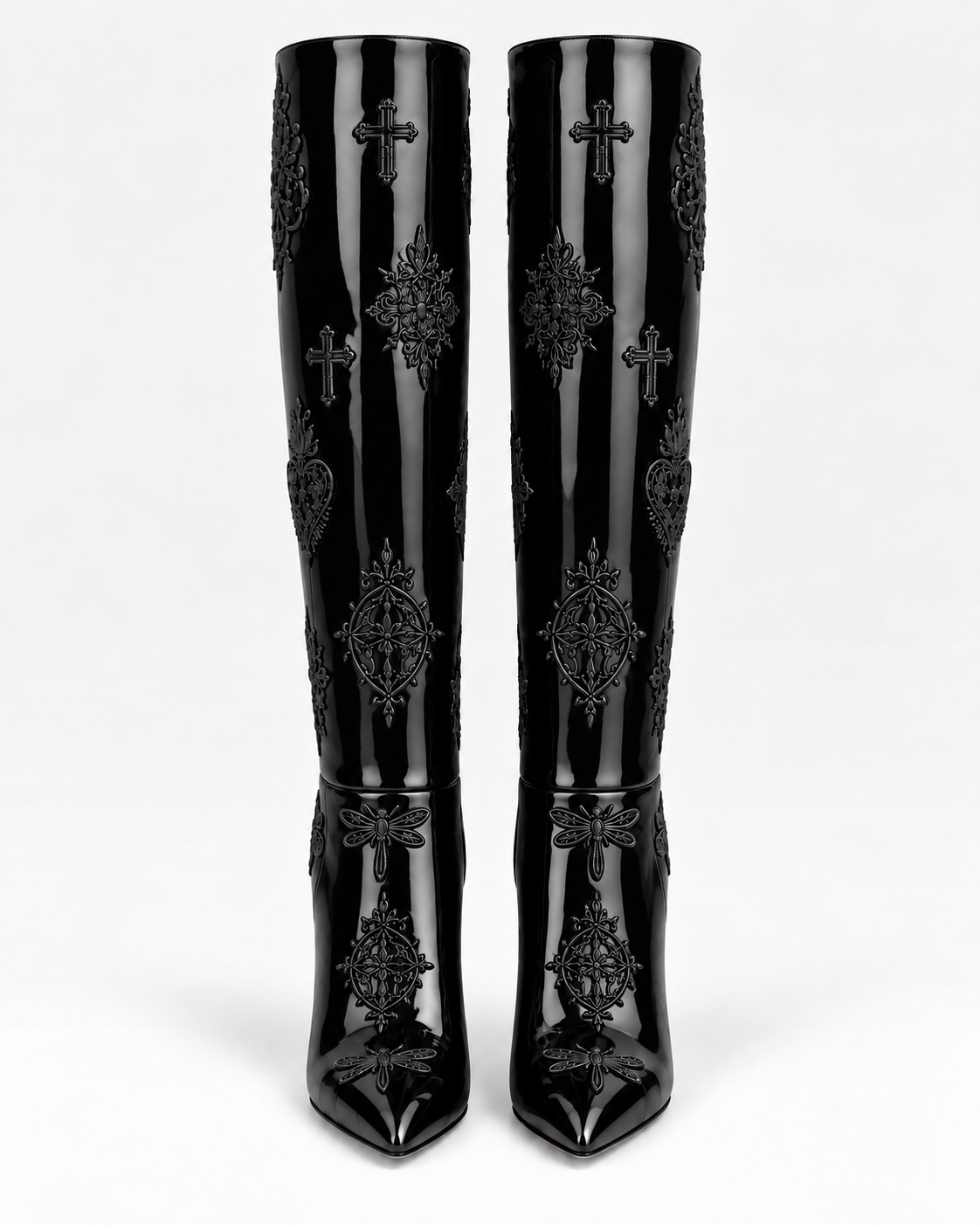 Front view of the shiny black patent leather embroidered tall boots, showing tonal motifs along the shafts and pointed toes.