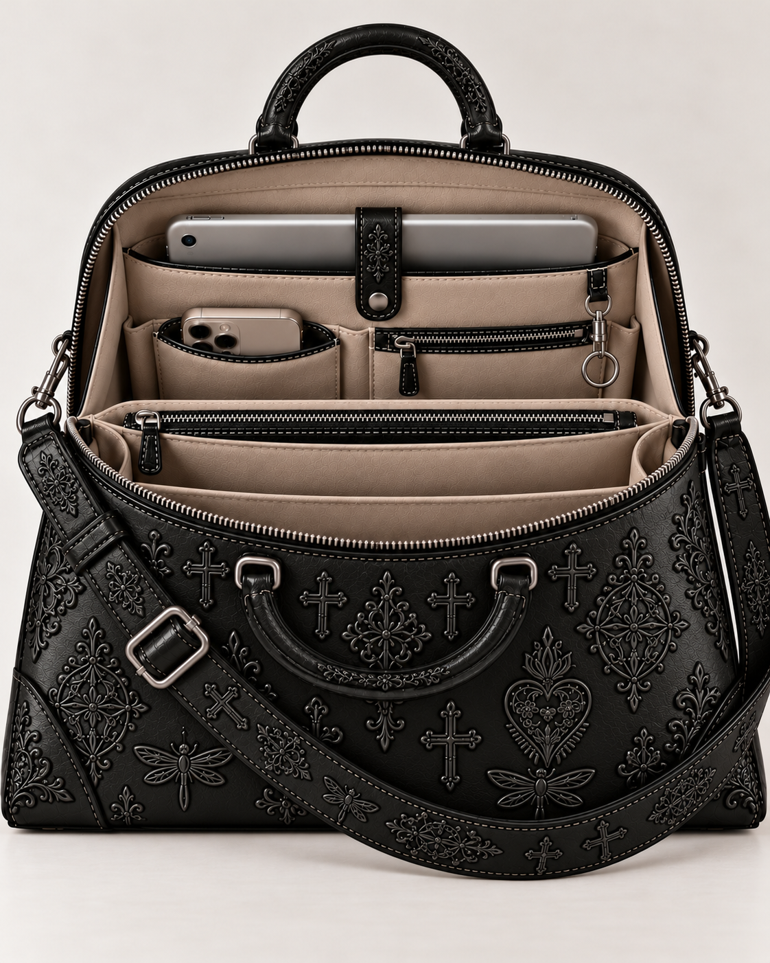 Interior view of the black leather embroidered handbag, showing beige compartments, phone and tablet pockets, zipped storage and a key ring.