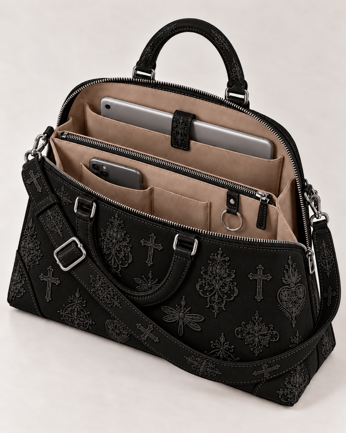 Open view of the embroidered handbag, showing a beige interior, divided compartments, zipped pocket, device pockets and key ring.