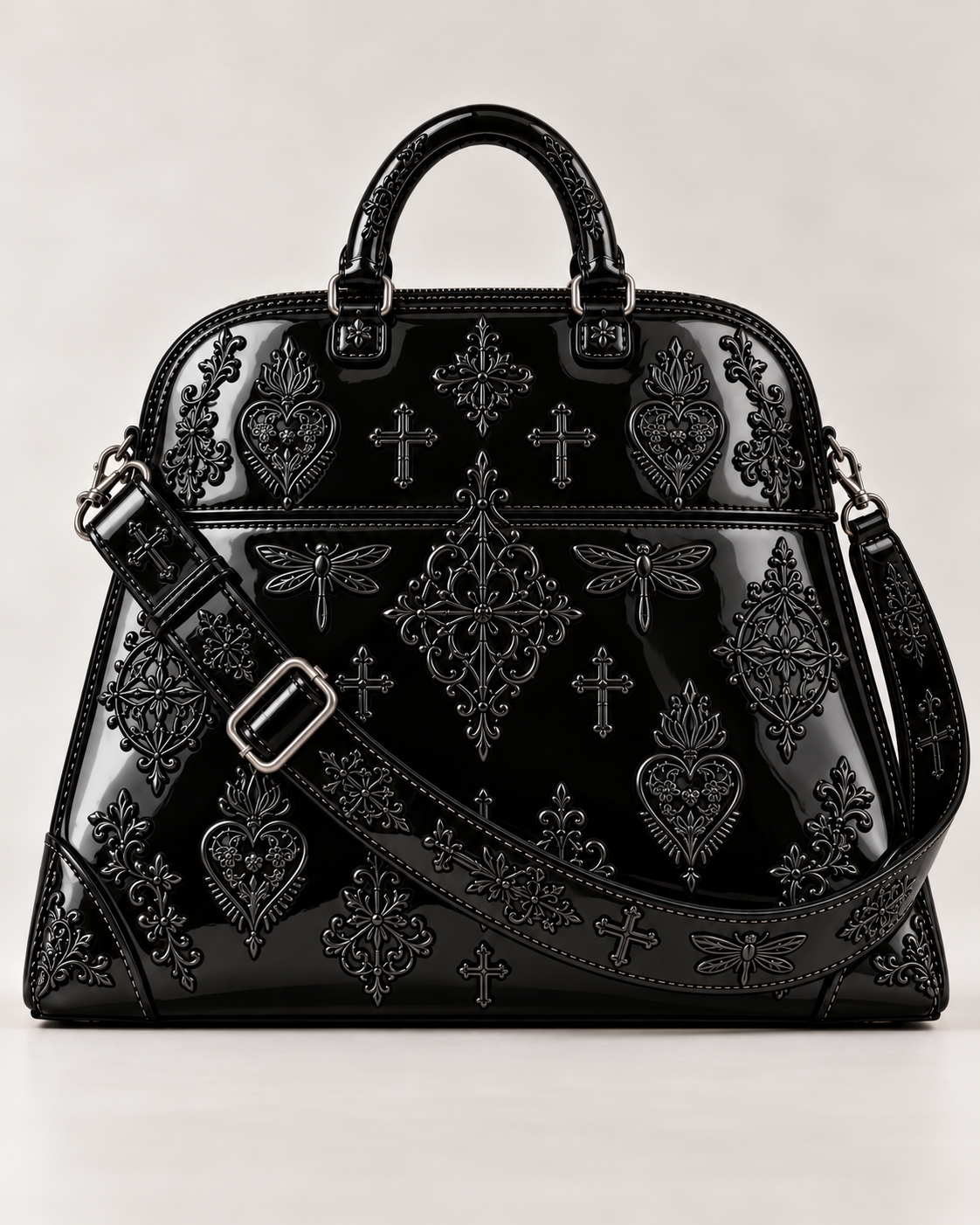 Front view of the LIGNES D’OMBRE embroidered structured handbag in shiny black patent leather, showing rounded handles and an adjustable strap.