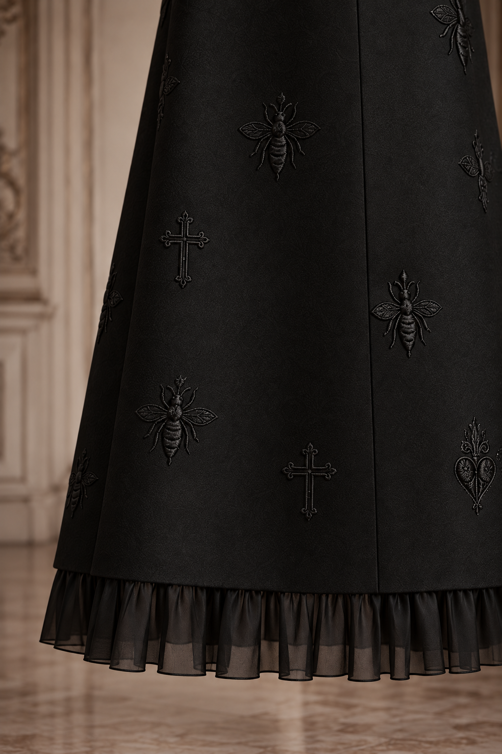 LIGNES D’OMBRE High-Collar Embroidered Ruffle-Hem Midi Dress in Black, close view of tonal bee embroidery and the gathered sheer chiffon ruffle at the hem.
