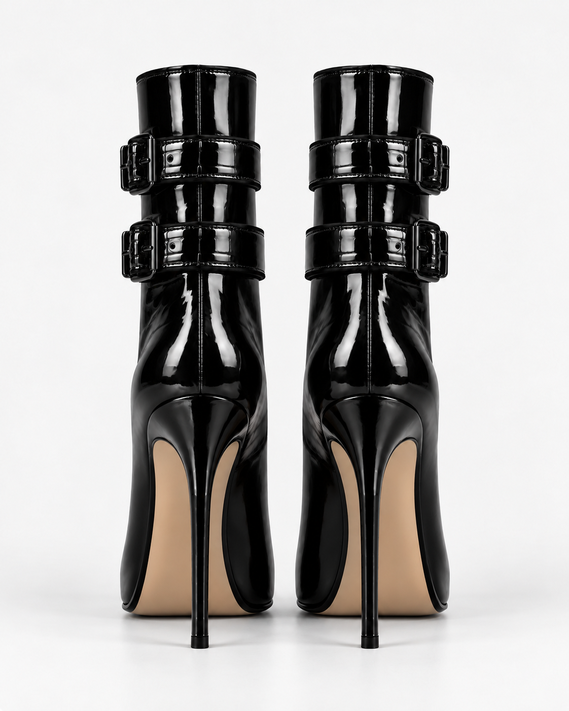 Back view of the glossy black double-buckle ankle boots, showing the shaft seams, buckled straps and stiletto heels.